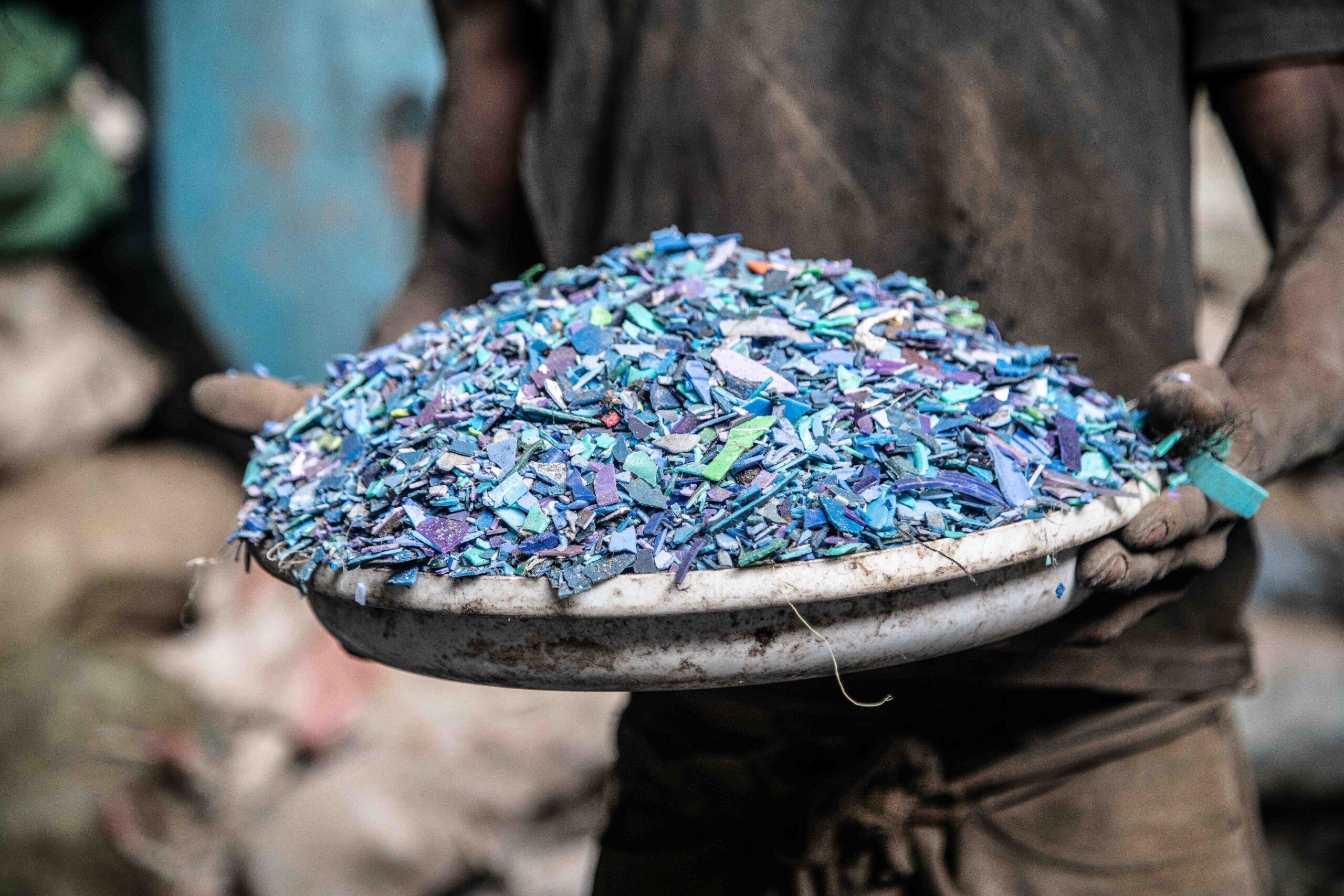 Person carrying a dish of plastic fragments. Photo by James Wakibia.